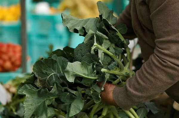 A man buys broccoli at the Farmers Market in Ta Qali