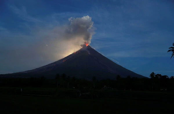 Mayon Volcano emits lava and ash during a mild eruption while illuminated by a super blue