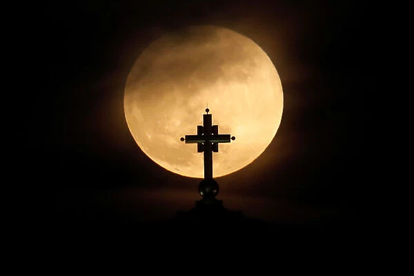A full moon rises behind St. Sava temple in Belgrade