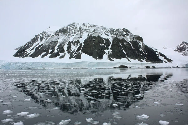 Mountain is reflected in a bay that used to be covered by the Sheldon glacier on the