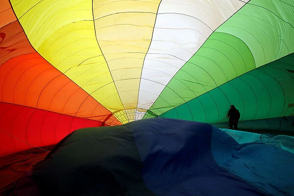 A Participant prepares a balloon for inflation during the International Hot Air Balloon
