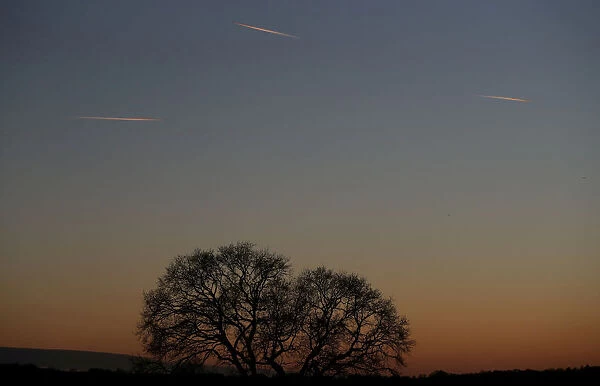 Passenger planes leave behind contrails as they fly in the skies over London Luton