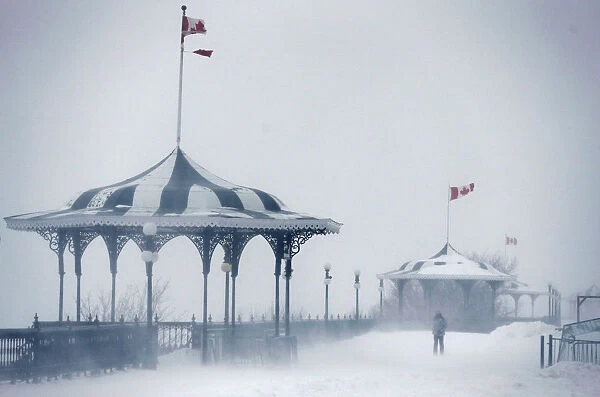 A pedestrian walks on the Terrasse Dufferin during a snowstorm in Quebec City