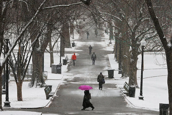 Pedestrians walk through Boston Common during a winter snow storm in Boston