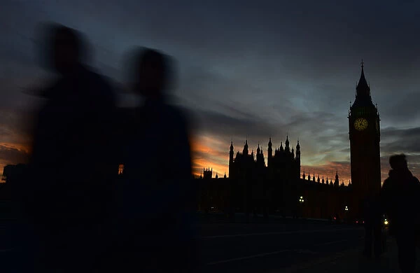 Pedestrians walk over Westminster Bridge with Big Ben and the Houses of Parliament seen behind