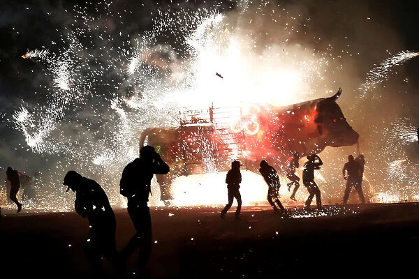 People enjoy fireworks exploding from a traditional bull known as Torito during the