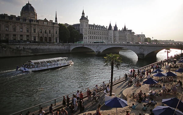 People enjoy the sun as Paris Beach opens along the banks of River Seine in Paris