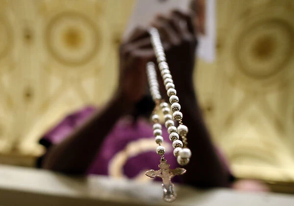 A person prays with a rosary as Pope Francis leads the Holy Rosary at the Saint Mary