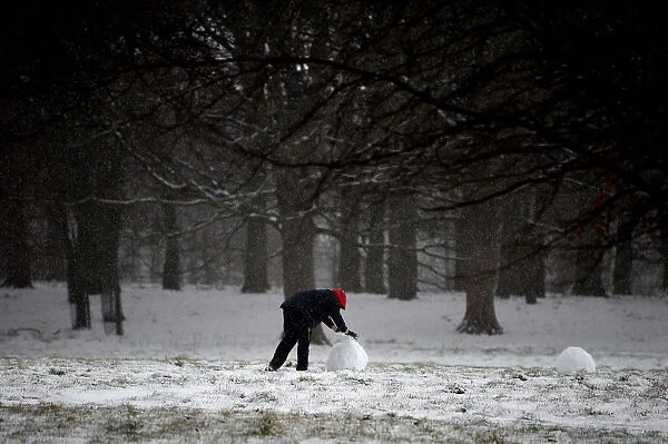 A person rolls a snowman at the Phoenix Park in Dublin