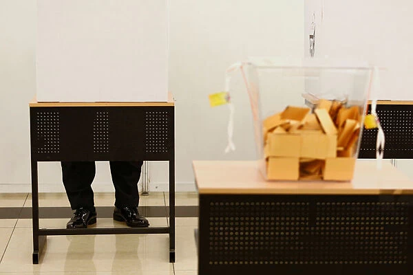 A police officer fills his ballot paper during the early voting ahead of the 14th general