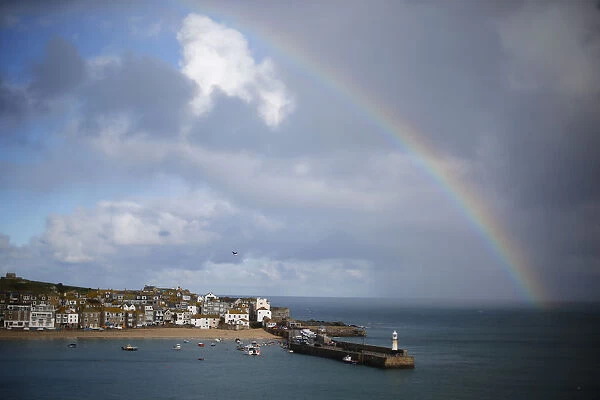 A rainbow forms as a squall moves past the harbour in St Ives in Cornwall