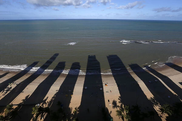 The shadows of buildings are cast on Piedade beach in Recife