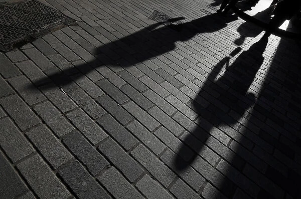 The shadows of workers are seen in the City of London financial district, London, Britain