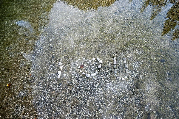 A sign made from stones is pictured in the Idrijca river in Idrijska Bela
