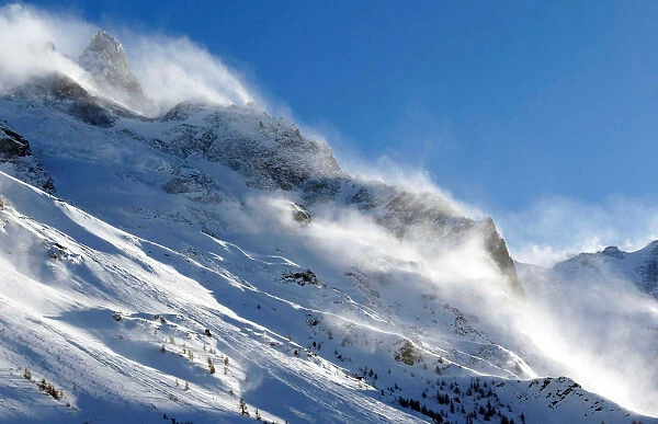 The snow sails to the top of a snowy mountain in Saint-Pancrace as winter weather