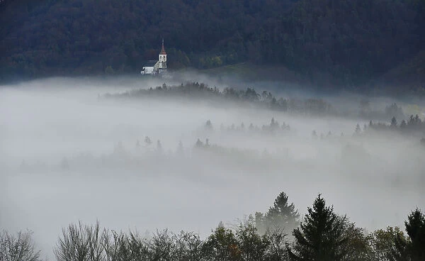 St. Margaret church is seen out of evening fog in the village of Zlebe