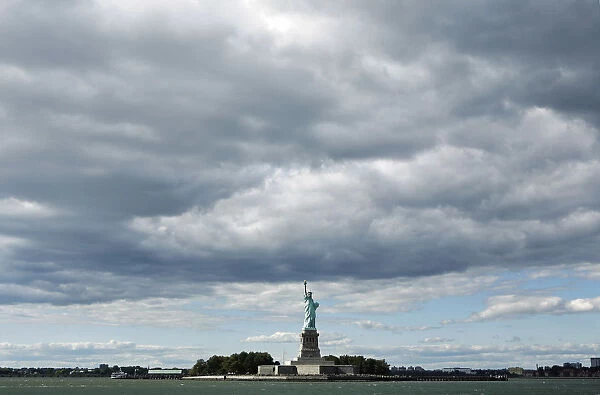 The Statue of Liberty can be seen underneath cloud cover in New York