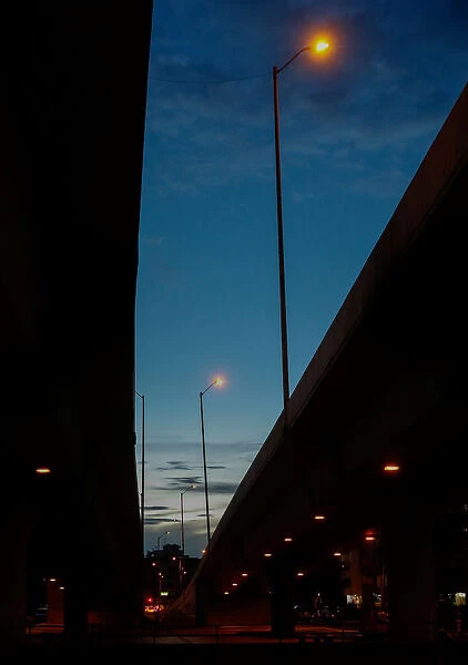 Street lights are seen between viaducts during dusk in Bogota city
