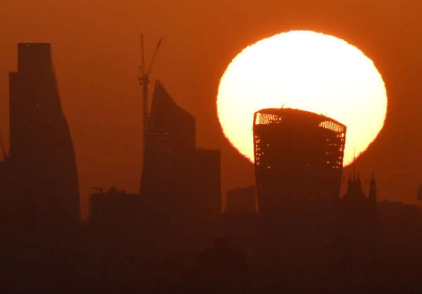The sun is seen rising over skyscrapers in the City of London financial district in
