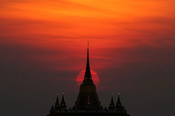 The sun sets behind Wat Saket Temple, or Golden Mount in Bangkok