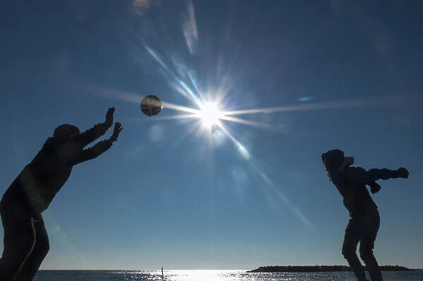 Tourists play with a ball on the beach on a sunny day at Valras-Plage