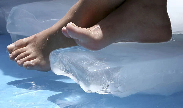A Turkish girl rests her feet on an ice block to cool herself in a pool in Istanbul