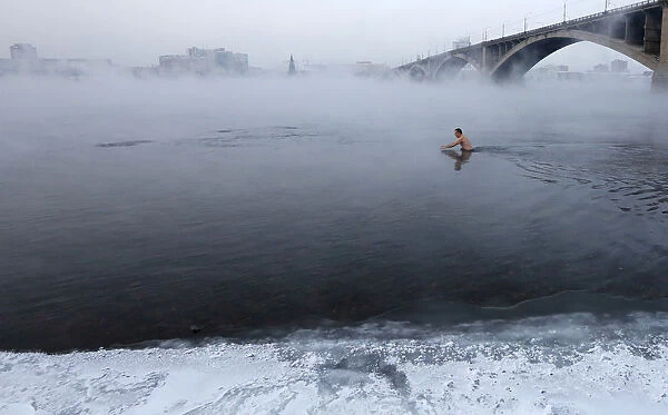 Vladimir Shcherba, a fan of winter swimming, dips to the Yenisei River at air temperature