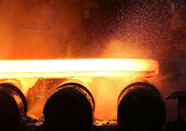 Water and steam fly off of a slab of steel rolls down the line at the Novolipetsk Steel