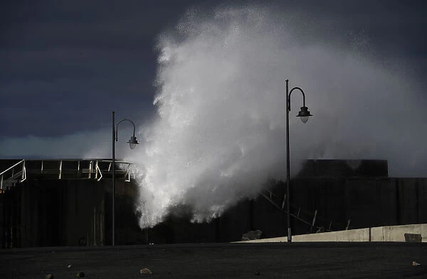 Waves crash against a seafront a the port town of Puerto de Vega