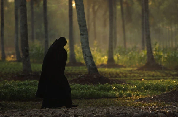 A woman from the Islamic sect An-Nadzir walks to an Eid al-Adha mass prayer at Mawang