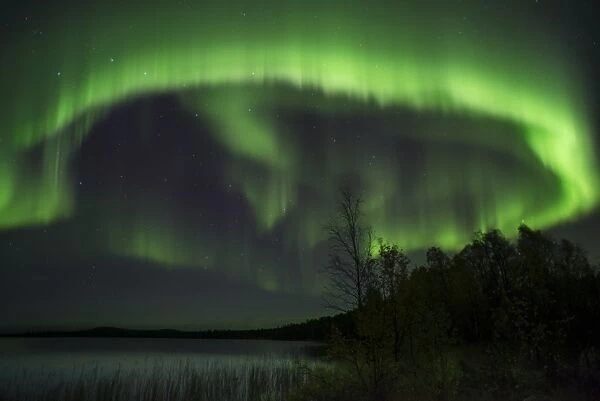 Aurora Borealis and stars over lake at night, Muonio, Lapland, Finland, September
