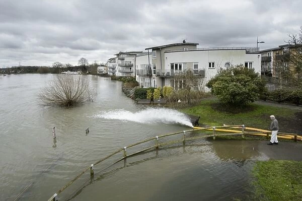 Floodwater pumped back into river during flood, River Thames, Chertsey, Surrey, England, February 2014
