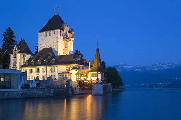 View of lakeside castle illuminated at night, Oberhofen Castle, Lake Thun, Oberhofen, Bernese Oberland, Switzerland