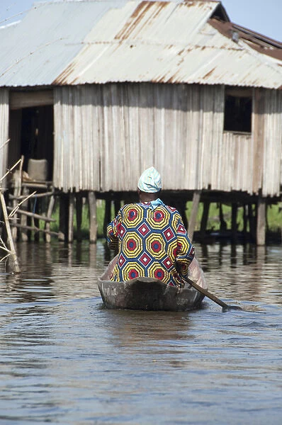 Africa, Benin, Ganvie. Tofinu villager in dugout canoe on the waters of Lake Nokoue