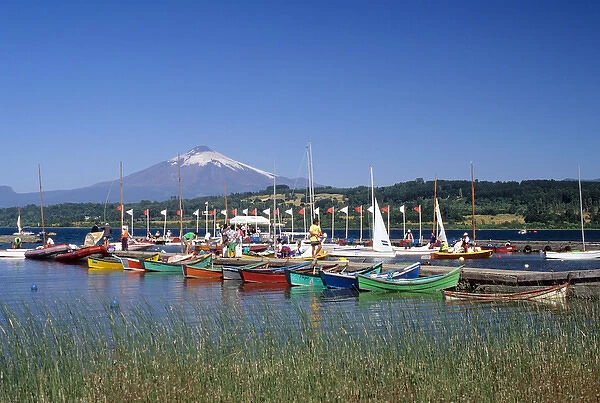Boats docked at a marina with Villarica volcano in Villarica, Chile