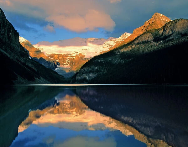 Canada, Alberta, Lake Louise. Sunrise brightens the still waters of Lake Louise, Banff NP