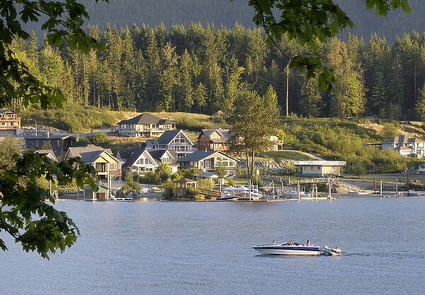 Canada, British Columbia, Cowichan Lake. Ski boat on Cowichan Lake in front of houses