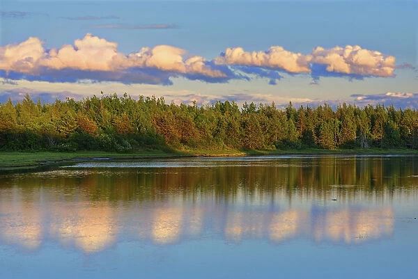 Canada, New Brunswick, Richibucto. Clouds reflected in an inlet at sunset. Credit as