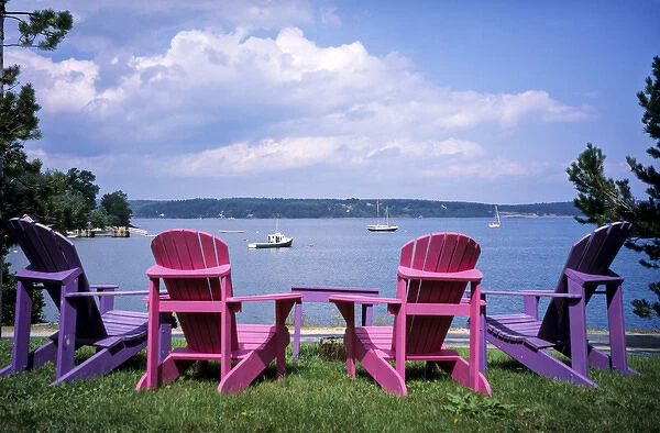 Canada, Nova Scotia, Mahone Bay; Colorful Adirondack chairs overlook the calm bay