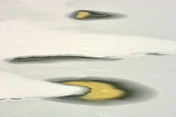 Canada, Ontario, Minet. Water pools on icy Lake Joseph reflect sunset. Credit as