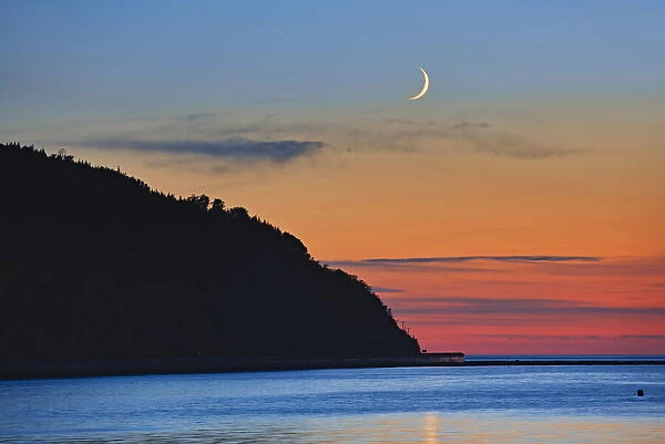 Canada, Quebec, Mont-Louis. Crescent moon sunrise on Gulf of St. Lawrence