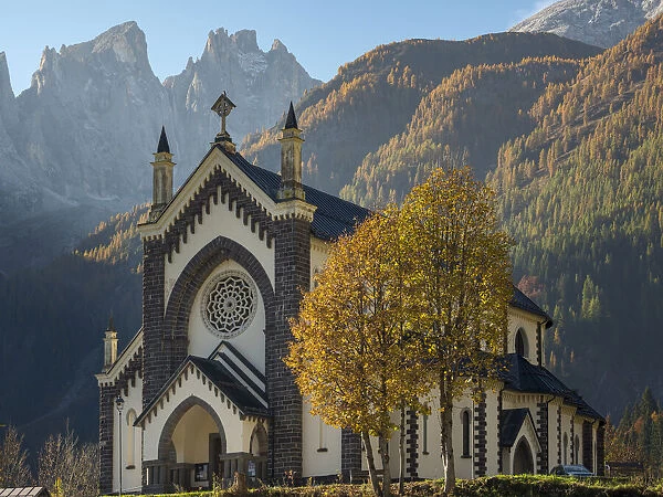 Chiesa di San Sebastiano in Falcade in Val Biois, in the background the Focobon mountain