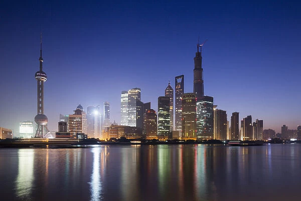 China, Shanghai, Glow of twilight behind towering skyline of Pudong district along