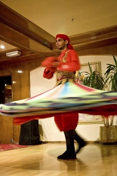 Egypt, Cairo. Whirling dervish dazzling GCT audience on Nubian Night aboard MS River
