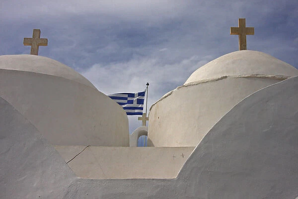 Europe, Greece, Cyclades, Sifnos, Vathi. Traditional Greek Orthodox church flying Greek flag
