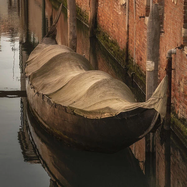 Europe, Italy, Venice. Covered old gondola on canal