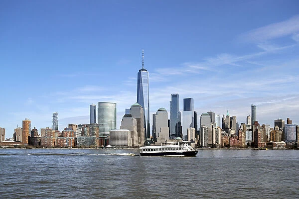 A ferry on the Hudson River passes by One World Trade Center and Manhattan buildings