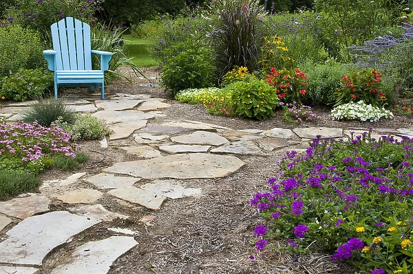Flower garden with path and blue chair. Homestead Purple Verbena, Tapien pink verbena
