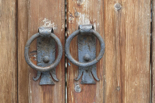 Georgia, Mtskheta. A close view of worn handles on a wooden gate