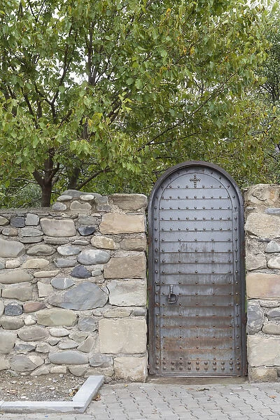 Georgia, Mtskheta. A metal door and rock wall